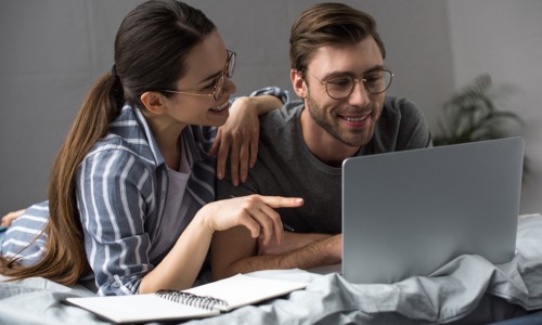 couple planning a year without spending using laptop