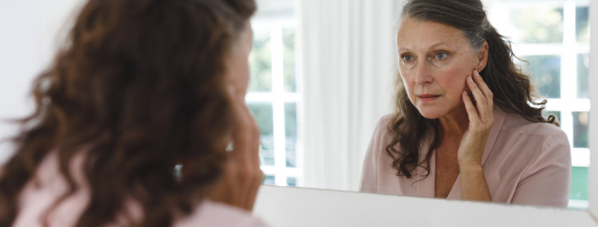woman looking in mirror diagnosing herself with disease to please