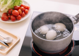 Three eggs boiling in pan of water