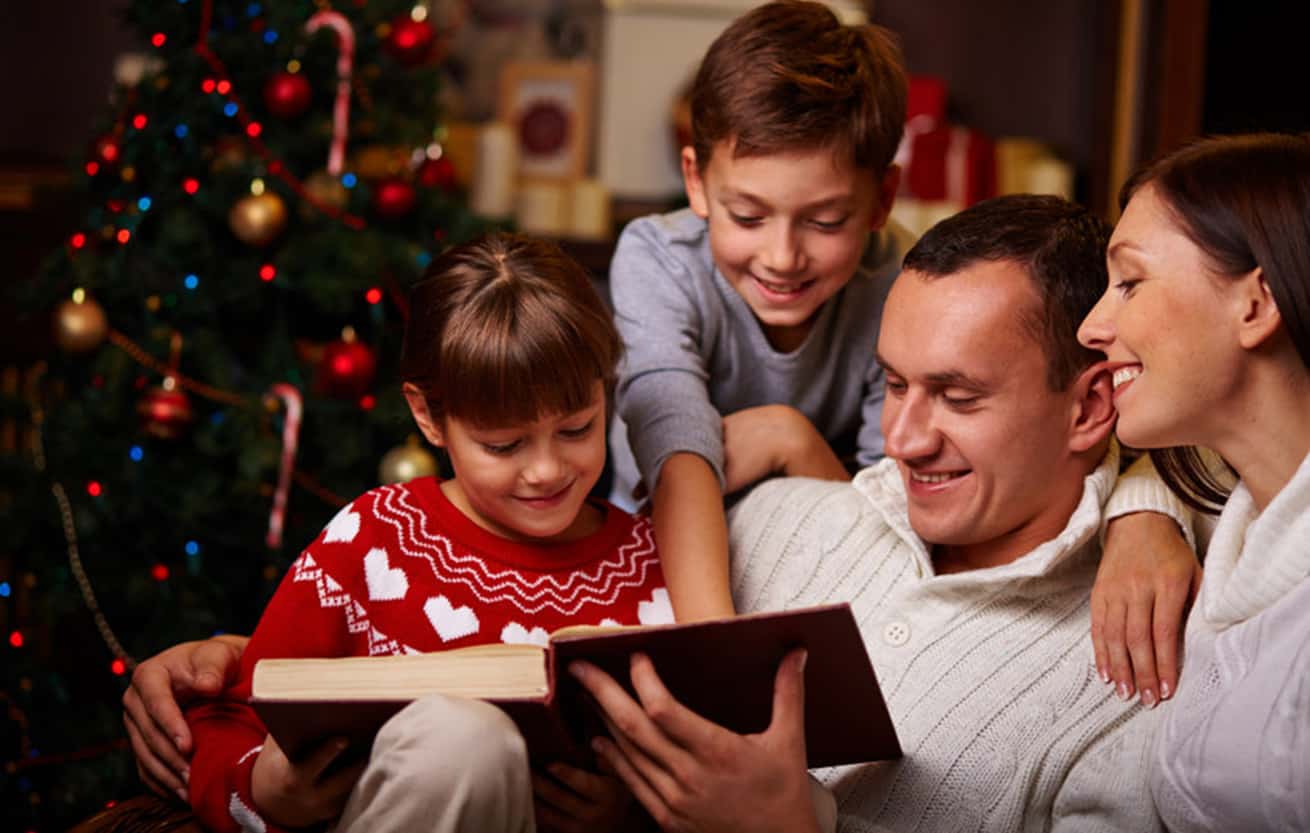 Modern family of four reading Christmas fairy tales