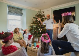 Family tradition of playing a game in front of Christmas Tree