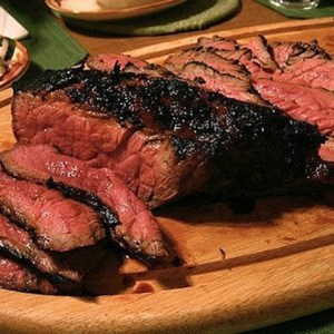 flank steak sliced on wood platter