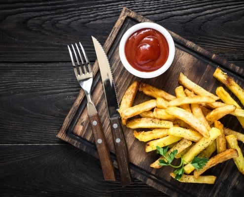 ketchup with french fries on wood tray