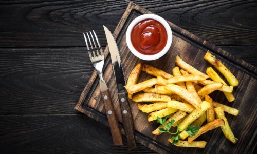 ketchup with french fries on wood tray