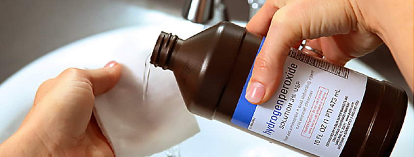 closeup of female hands pouring hydrogen peroxide into a clean cloth