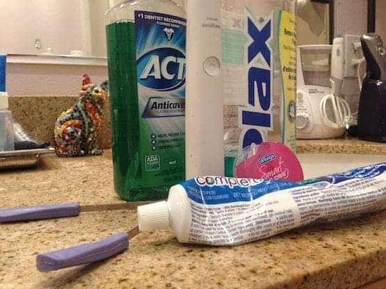 Bathroom counter showing dental care products
