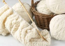  Fil de laine naturelle et tricot sur fond en bois vintage.
