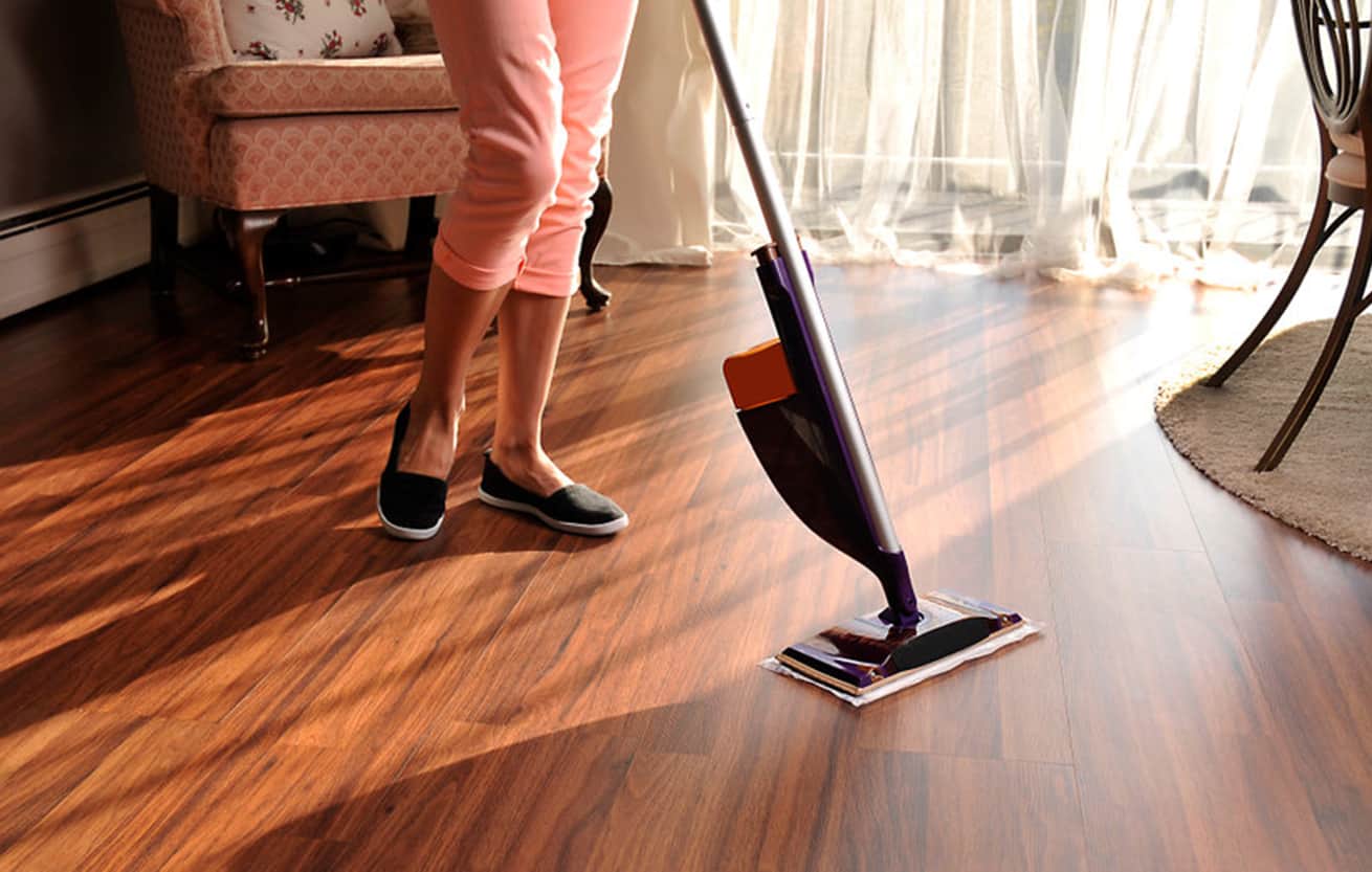 female cleaning laminate floor with modern spray mop