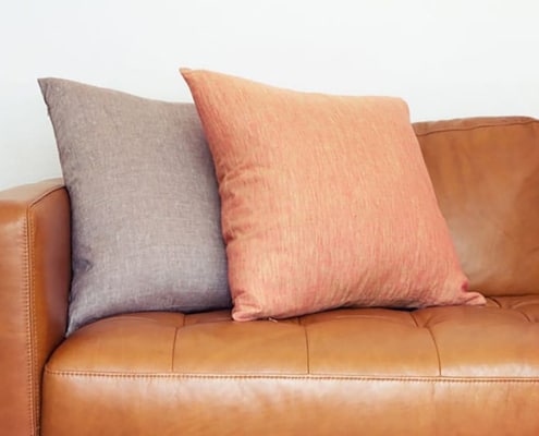 brown leather sofa with pillows of contrasting color