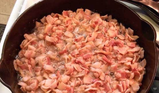 A bowl of food sitting on a pan, with Bacon