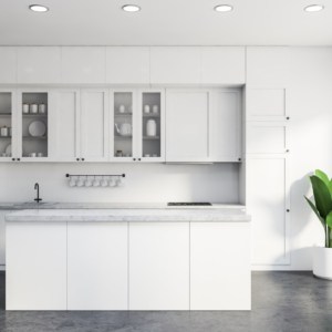 vInterior of classic kitchen with white and grey walls, concrete floor, white countertops and cupboards and comfortable white island