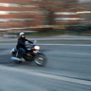 A man riding a motorcycle down a street