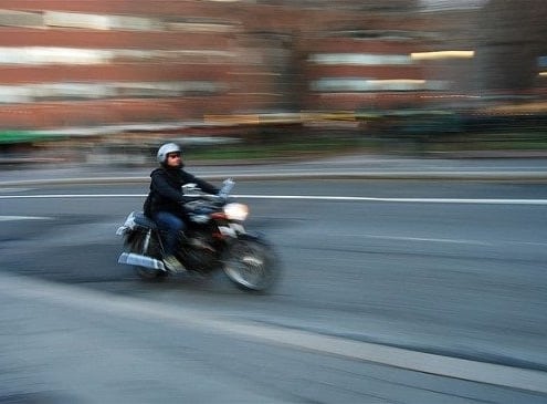 A man riding a motorcycle down a street