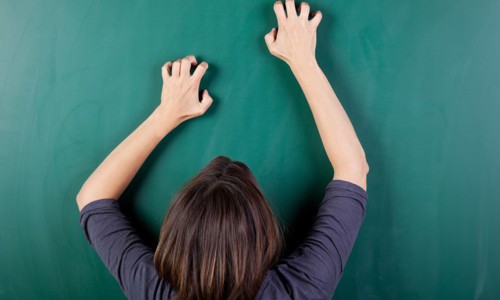 closeup rear view of frustrated woman scratching chalkboard