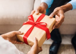 Father hands giving birthday gift to daughter