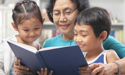 Grandma and grandchildren reading book together
