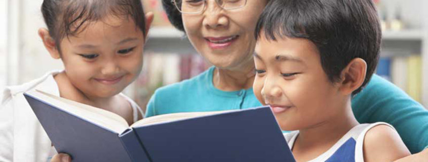 Grandma and grandchildren reading book together