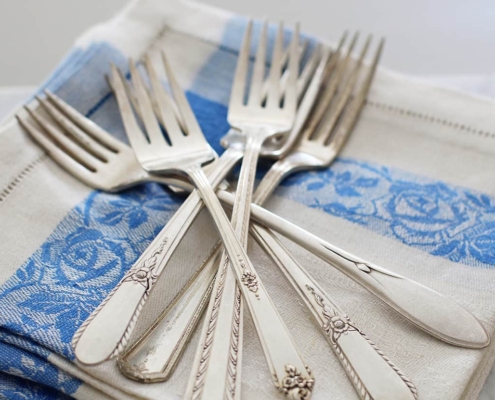 silver flatware forks on linen napkin