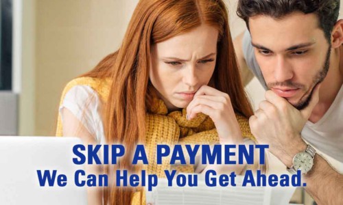 young couple perplexed by notice they can skip a payment