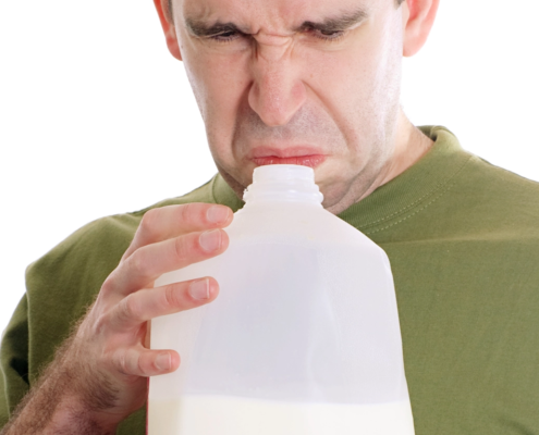 man smelling sour milk and not enjoying the experience