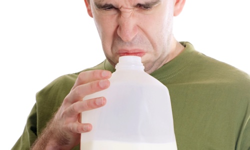 man smelling sour milk and not enjoying the experience
