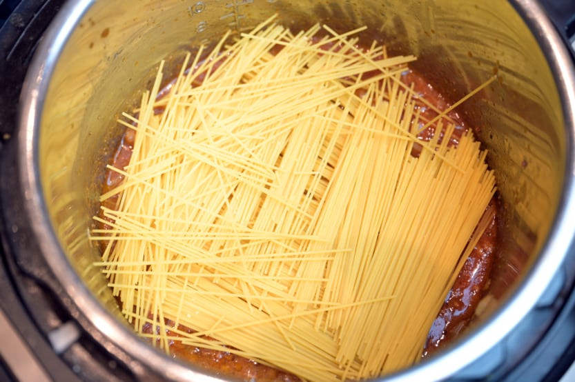 A close up of a bowl of soup, with Spaghetti and Sauce