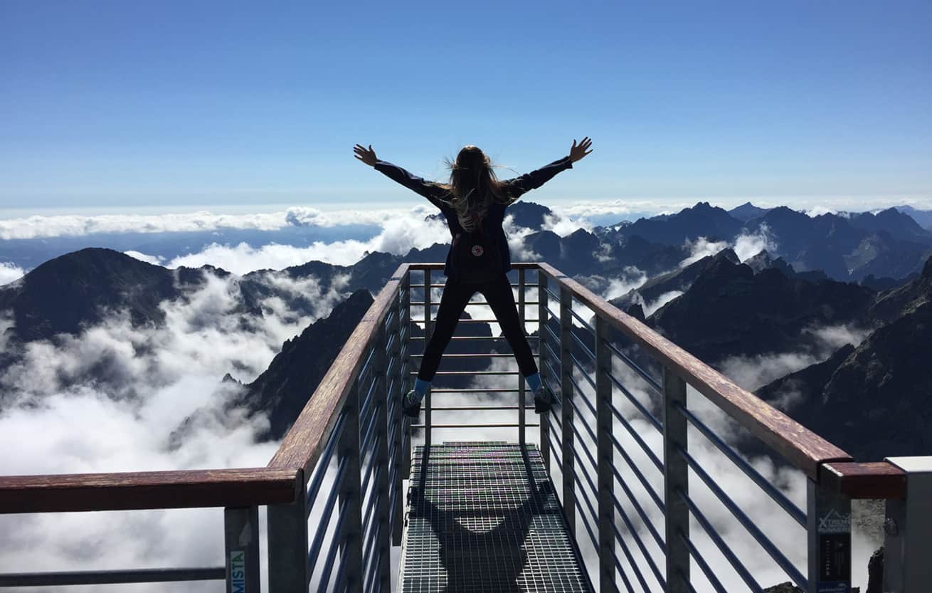Woman hands up success concept reachingn mountaintop goal