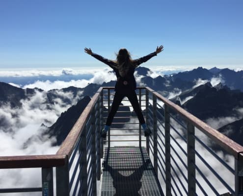 Woman hands up success concept reachingn mountaintop goal