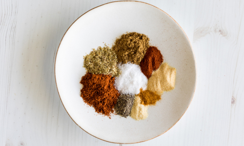 A plate of piles of various spices used in making a taco seasoning blend.