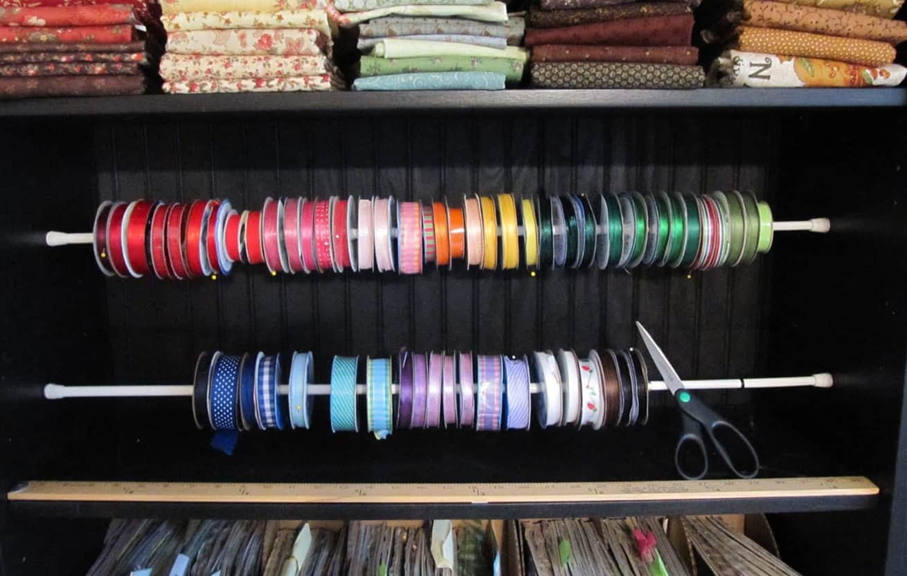 clever use of tension rods to organize spools of coloful ribbon