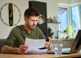 Man reviewing an insurance policy before deciding whether to file an insurance claim