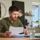 Man reviewing an insurance policy before deciding whether to file an insurance claim
