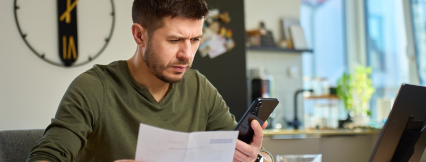 Man reviewing an insurance policy before deciding whether to file an insurance claim