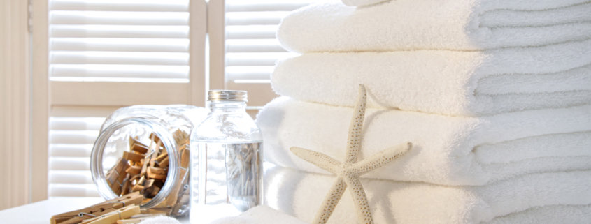 Fluffy white towels on table with shutter doors