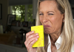 woman smelling stinky sponge